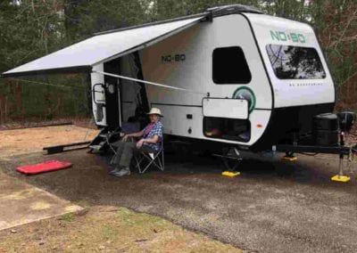 guy under awning of travel trailer rental